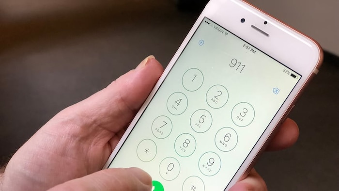 Une personne compose le 911 sur son cellulaire. 