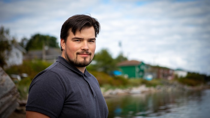 Michael Vegh devant des maisons à Bella Bella.