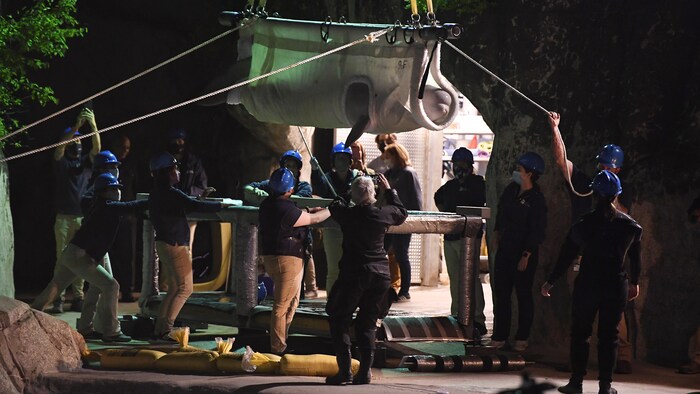 Un béluga est transporté à l'aquarium de Mystic après son arrivée du Canada, en 2021 dans le Connecticut. De nombreuses personnes sont autour de l'animal pour la logistique du transport.
