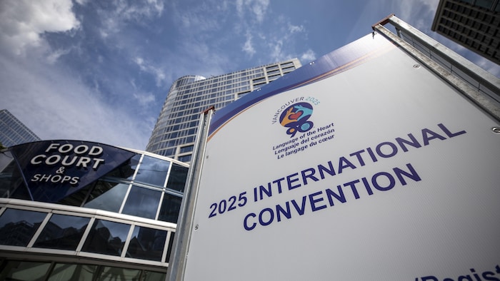 Une pancarte qui indique le Congrès international des Alcooliques anonymes de 2025, avec le logo de l’événement qui est deux mains qui forment un cœur.