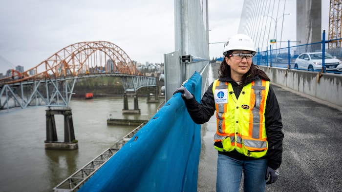 Wendy Itagawa se tient sur le pont Stal̕əw̓asəm tandis que des équipes déconstruisent l'ancien pont Pattullo.