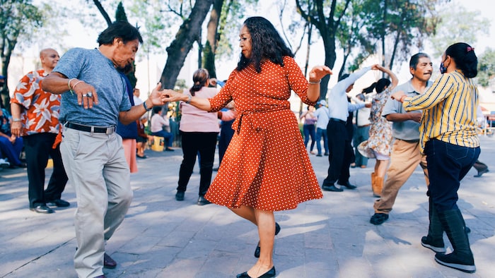 Des gens dansent dans la rue. 