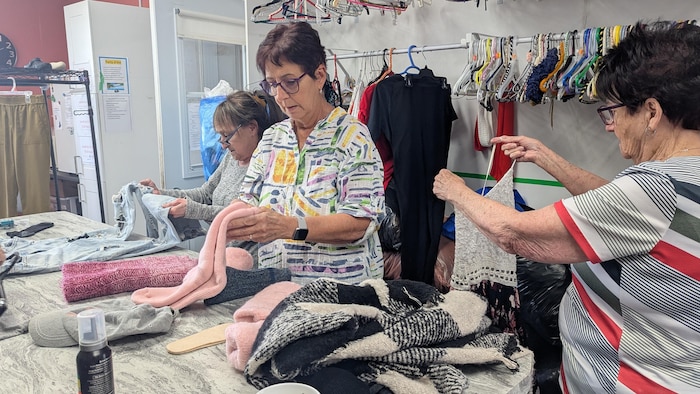 Les bénévoles analysent les morceaux de vêtements qu'elles reçoivent.