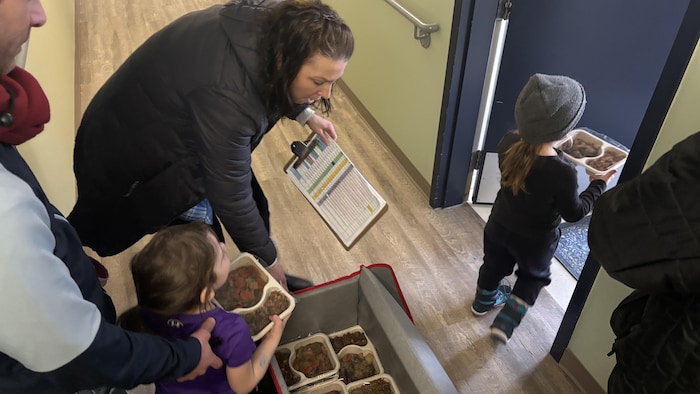 De jeunes enfants apportent des repas aux résidents à partir d'un grand sac.