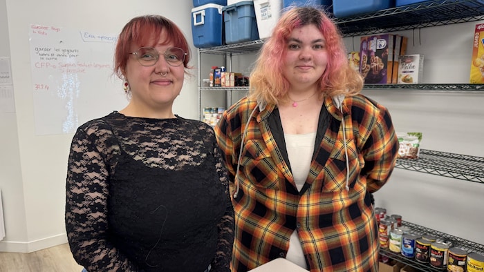 Deux jeunes femmes sourient à la caméra.