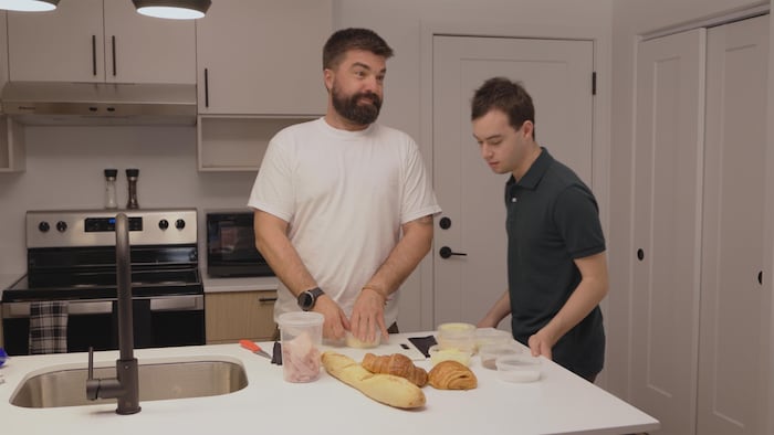 Deux hommes sont debout dans un condo. 