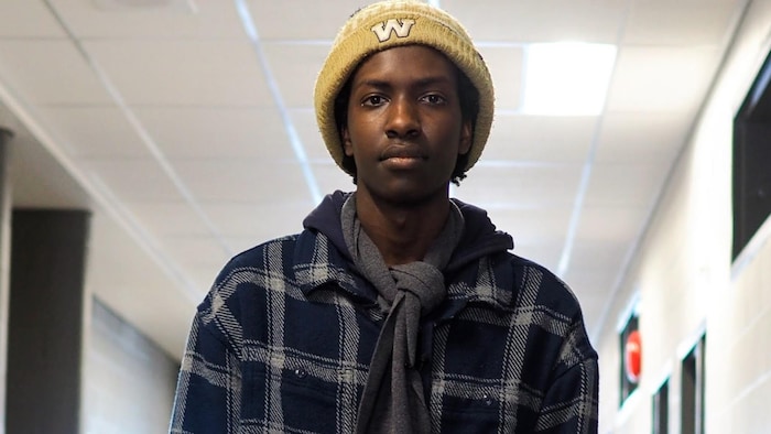 Benjamin Niyomugabo porte une écharpe sur laquelle est brodé DSFM.