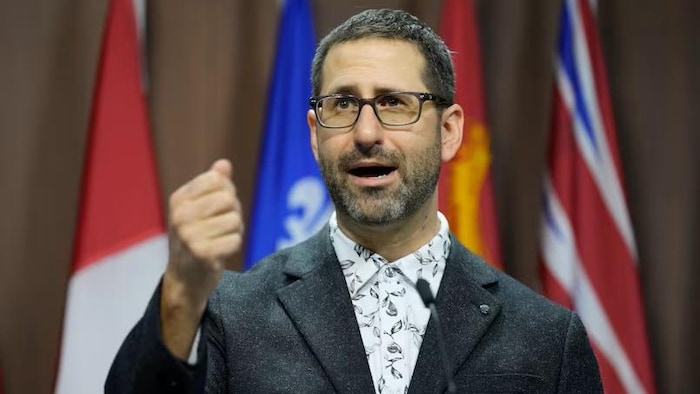 Benjamin Roebuck parle dans un micro.