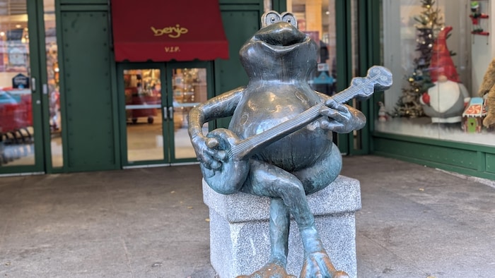 Une statue de grenouille devant le magasin de jouets Benjo.
