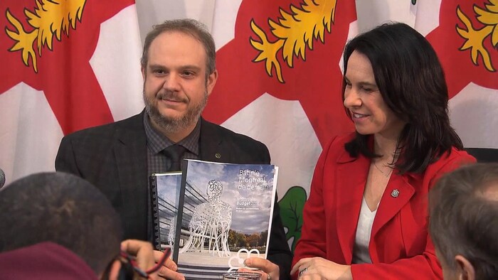 Benoît Dorais et Valérie Plante montrent le document du budget.