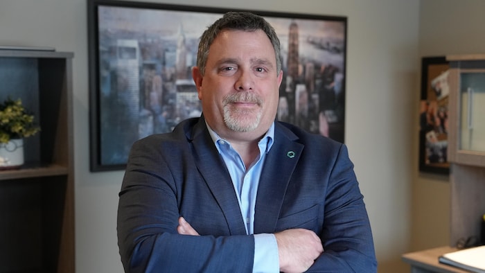 Benoit Durocher, debout dans un bureau, les bras croisés.