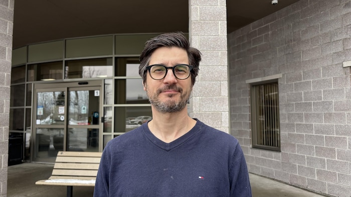 Un homme devant un bâtiment. 