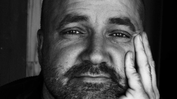 Portrait en noir et blanc d'un homme barbu.