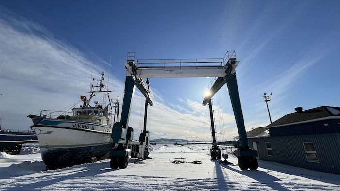 Le bateau Viking II est stationné dans la neige à côté d’un imposant ber cavalier bleu sous un ciel ensoleillé.