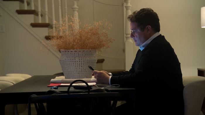 Un homme consulte son téléphone intelligent.