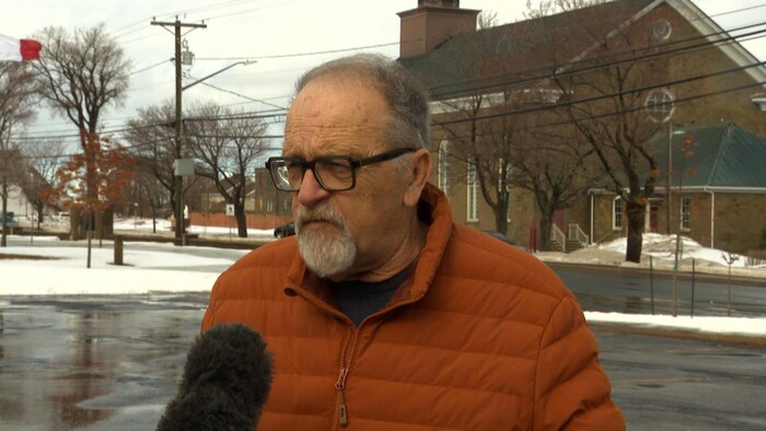 Un homme interviewé à l'extérieur.