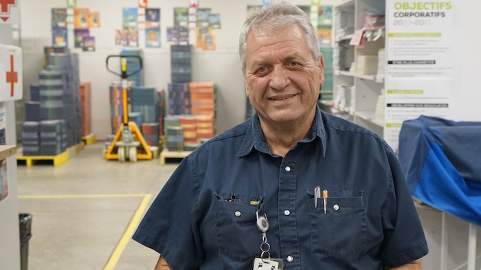 Portrait de l'homme dans son environnement de travail. Il œuvre pour une usine d'impression et de reliage.