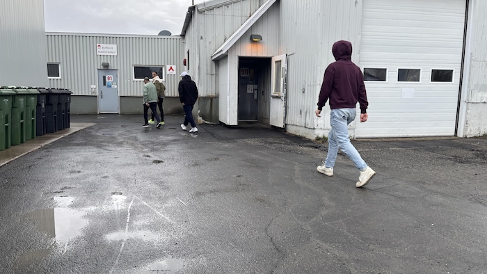 Des gens qui marchent vers un bâtiment.