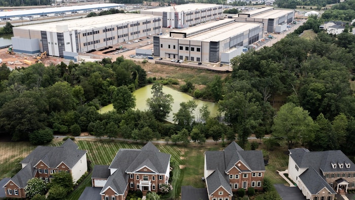 Un vaste centre de données à côté de maisons individuelles.
