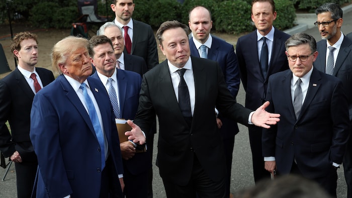 Un groupe d'hommes en complet et cravate devant des journalistes.