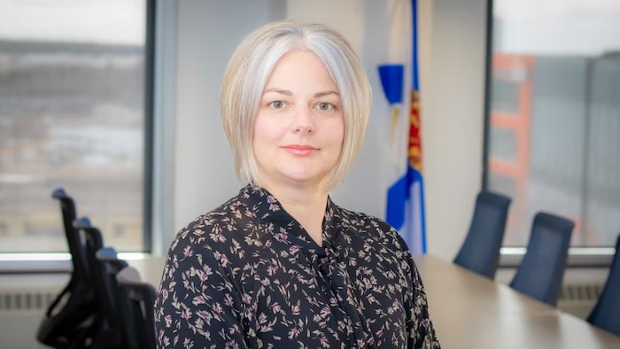 Portrait de Bethany McCormick, seule dans une salle de réunion.