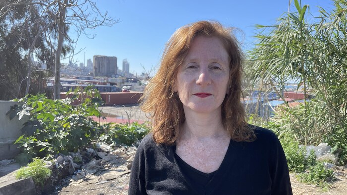 Une femme aux cheveux roux devant le port de Beyrouth.