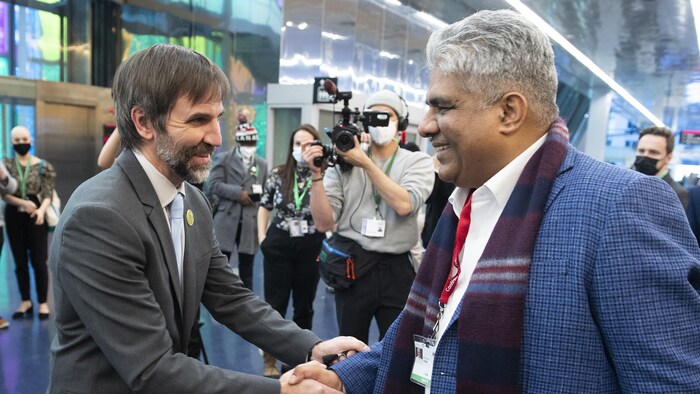 Steven Guilbeault, ministre fédéral de l'Environnement et du Changement climatique, sert la main du ministre indien de l’Environnement, Bhupender Yadav, lors de la COP15 sur la biodiversité à Montréal.