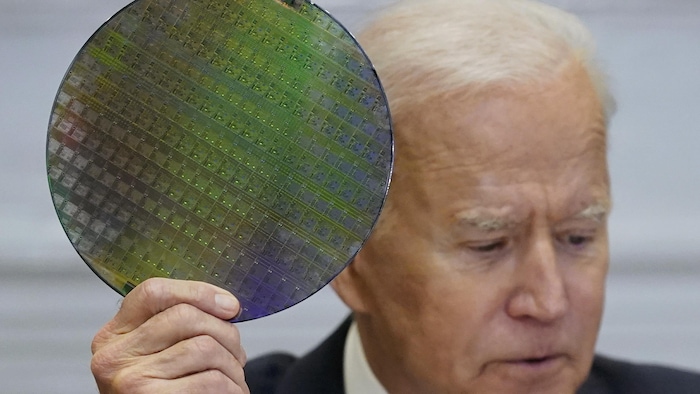 美國總統拜登舉起一塊用于制造微型芯片的半導體材料。