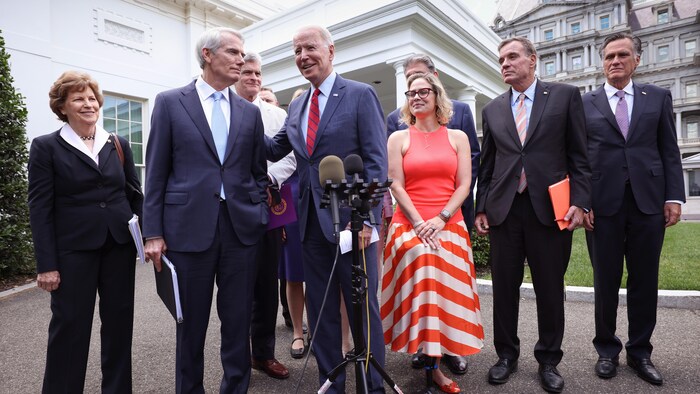 Joe Biden accompagné de sénateurs démocrates et républicains.
