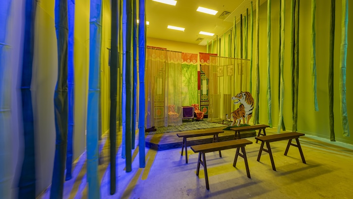 Un décor d'opéra cantonais, un tigre et des bancs figurent dans l'installation interactive créée par Karen Tam à la Biennale d'art de Toronto en 2024.