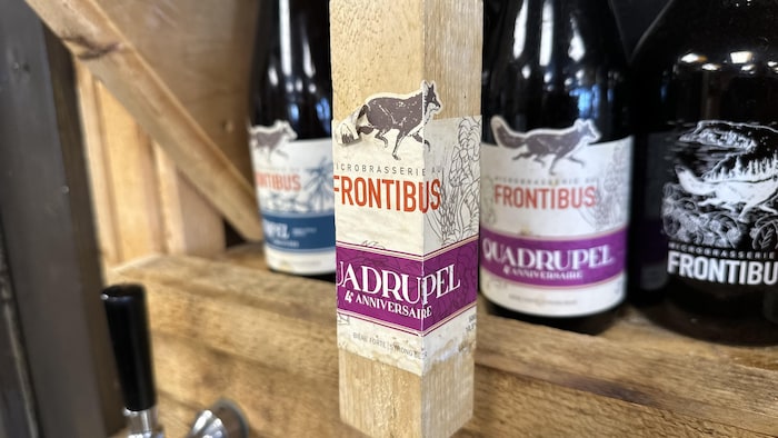 Barrel handle frontibus in front of beer bottles.