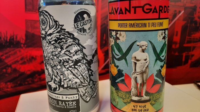 Deux canettes de bière sur un bureau. Une canette de la microbrasserie Le Castor et l'autre de la microbrasserie L'Avant-Garde.