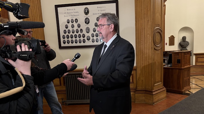 Bill Hogan répond aux questions des journalistes à l'intérieur de l'Assemblée législative à Fredericton.