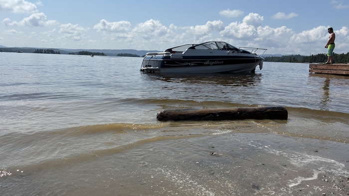 Un billot de bois en avant-plan et un bateau à l'arrière-plan.
