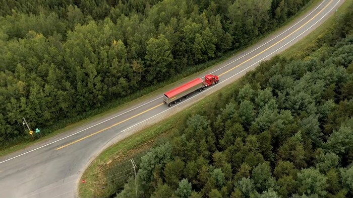 Un camion chargé de matières biosolides circule sur la route.