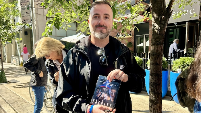 Un homme qui tient un Blu-ray du film The Faculty dans ses mains devant l'hôtel Bisha de Toronto.