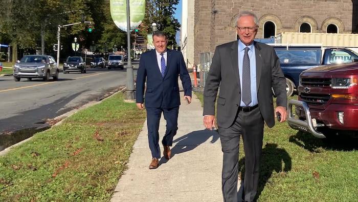 Blaine Higgs et Daniel Allain marchent sur un trottoir.