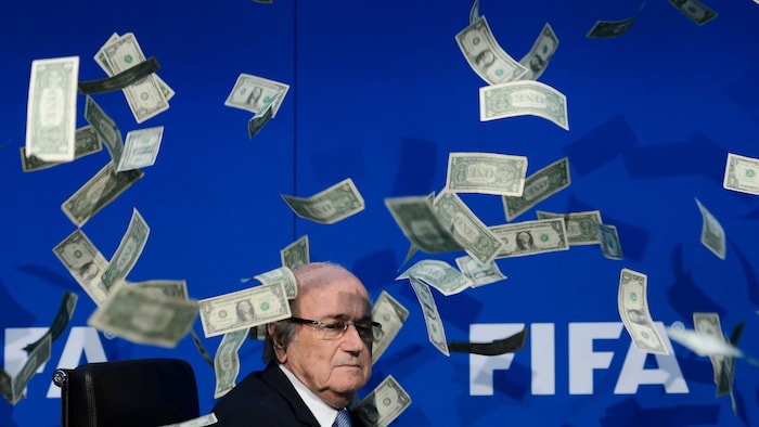 Un homme assis avec des billets de banque qui volent