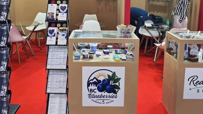 Un petit présentoir où il est écrit Conseil des producteurs de bleuets de la Colombie-Britannique, avec des produits dérivés du bleuet présentés.