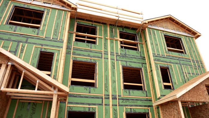 Un immeuble d'appartement de trois &eacute;tages en construction.