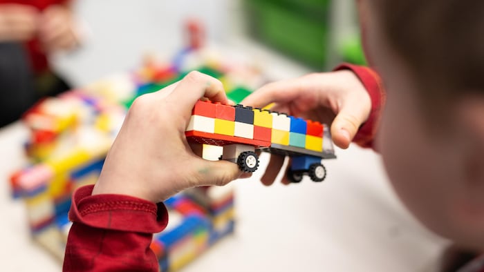 Un enfant tient des blocs Lego dans ses mains.