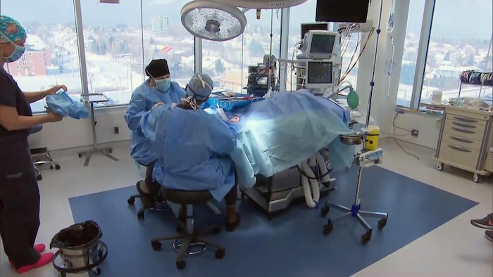 Des travailleurs de la santé dans une salle d'opération neuve avec de grandes fenêtres