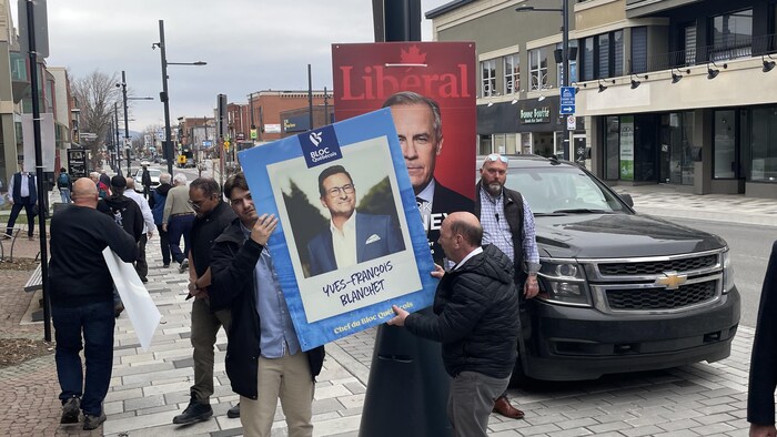 Des militants avec des pancartes.