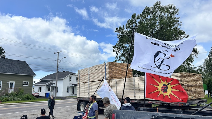 Des personnes brandissent des drapeaux, dont le Warrior.