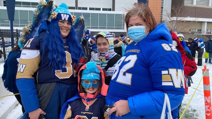 Deux femmes habillées en bleu avec deux petites filles au centre.