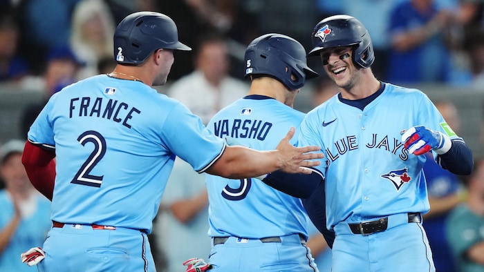 Ernie Clement, des Jays, célèbre aux côtés de Daulton Varsho et Ty France.
