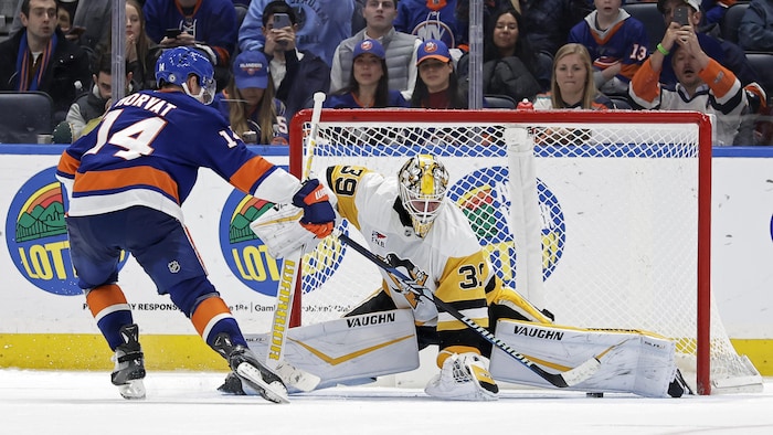 Le centre des Islanders de New York Bo Horvat (14) marque un but devant le gardien des Penguins de Pittsburgh Alex Nedeljkovic lors d'une fusillade, le mardi 5 novembre 2024.