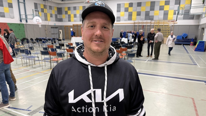 Bob Béchard souriant dans un gymnase.