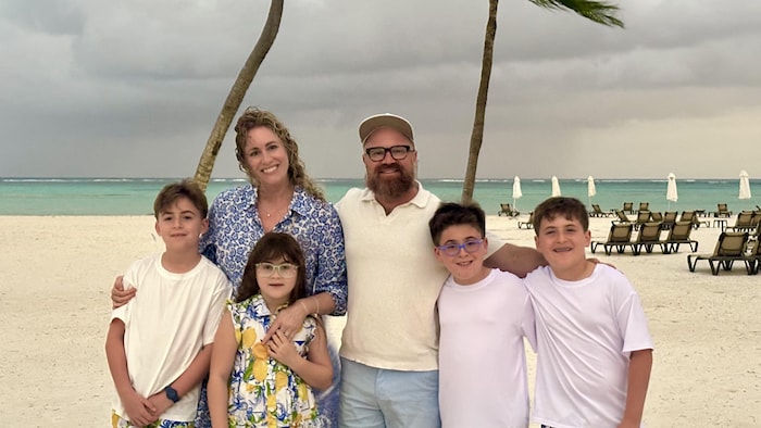 Une famille pose pour une photo à Boca Raton en Floride, au bord de la plage.