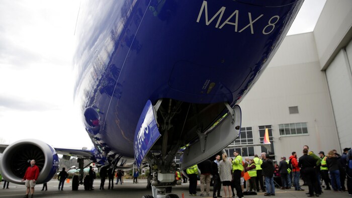 Des employés de Boeing devant un avion.